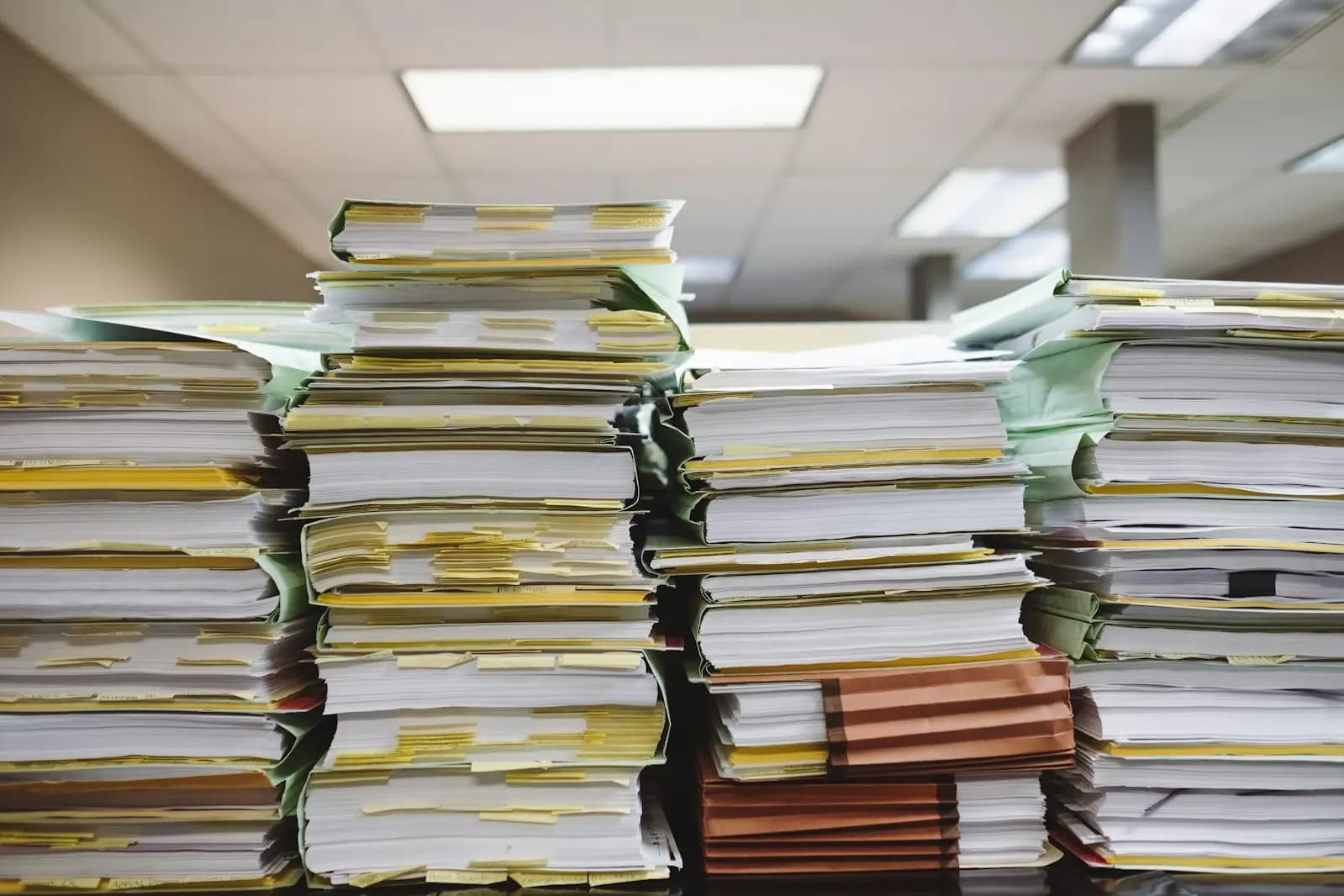 Tall stacks of paper files and claim records in an office