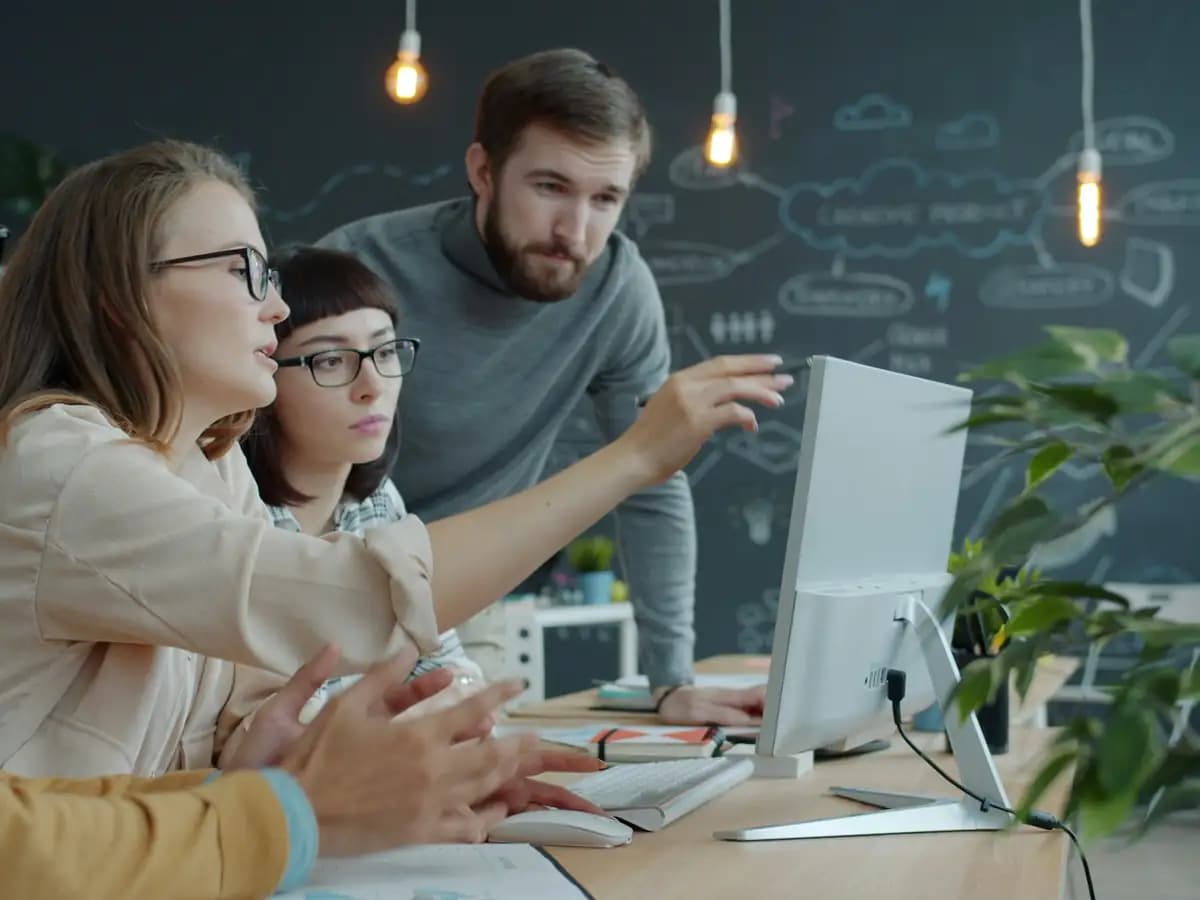 Colleagues reviewing work together at a computer