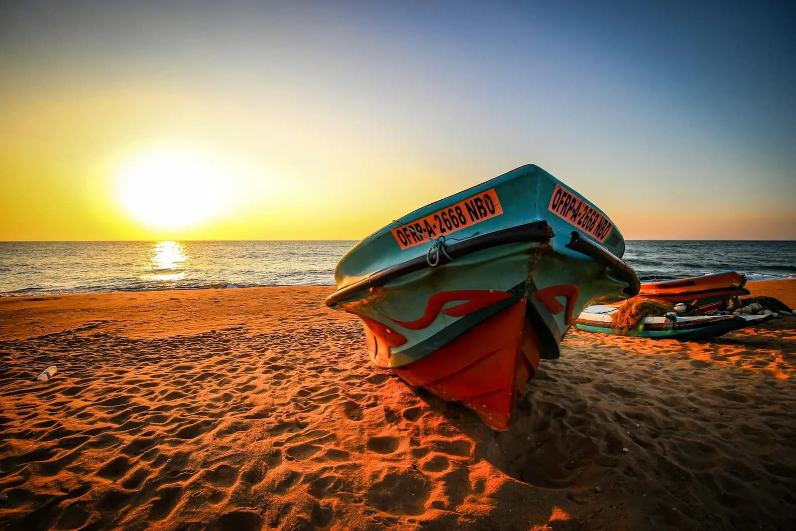 A traditional fishing boat on a Sri Lankan beach at sunset