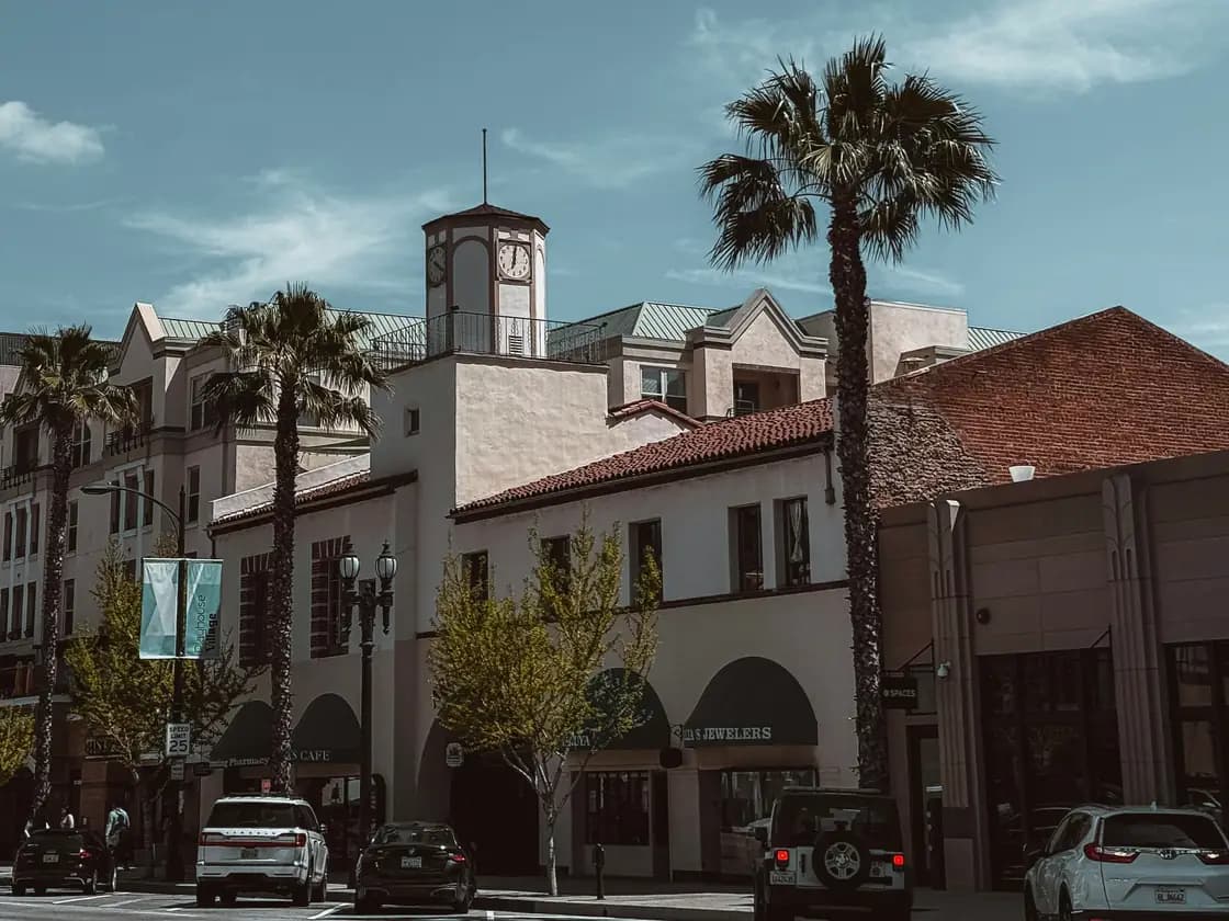 A Pasadena street lined with palm trees and Spanish style buildings
